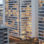 Edifícios em Brasília com placa de vende-se enferrujada, representando elevação do ITBI e complicações em transações no DF.