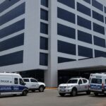 Fachada do Hospital Anchieta em Brasília com viaturas policiais, representando denúncias de mortes suspeitas após prisões por injeções irregulares.