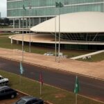 Hospital em Brasília com marcas de raio em área de manifestação, representando visita a vítimas.