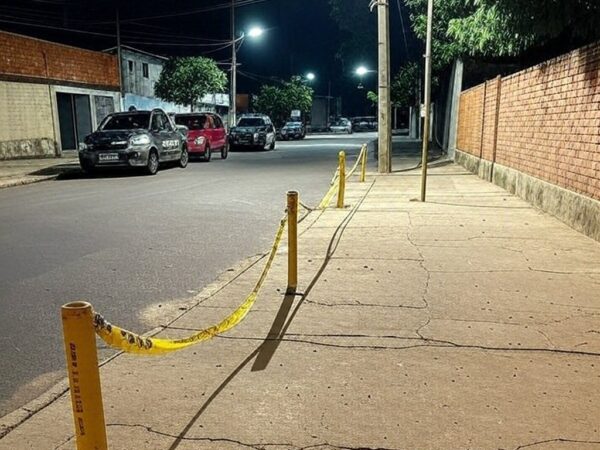 Cena de rua no Itapoã, DF, com fita de isolamento policial e viaturas após ataque armado.