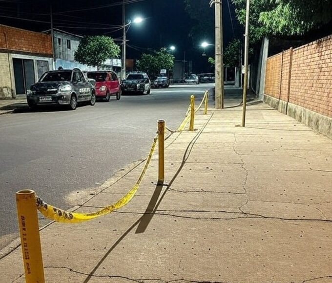 Cena de rua no Itapoã, DF, com fita de isolamento policial e viaturas após ataque armado.