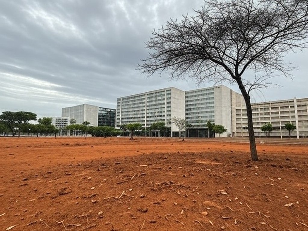 Vista urbana de Brasília com edifícios modernos e pouca arborização, ilustrando atraso em política ambiental.