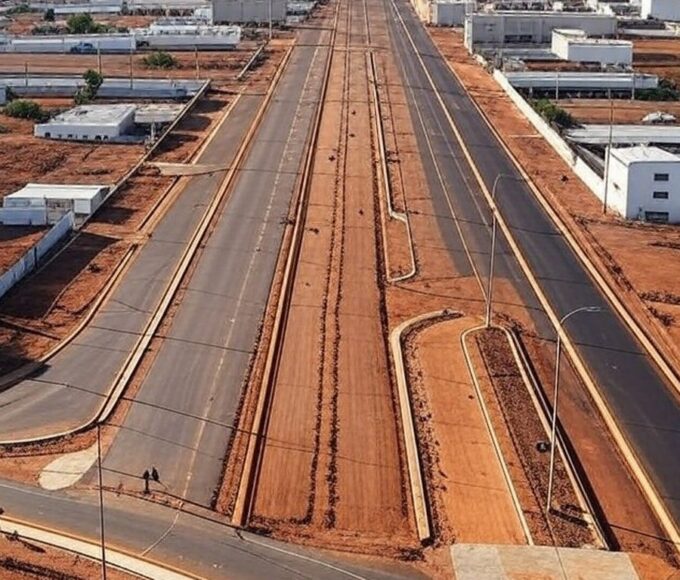 Obras de pavimentação e ciclovias em rua de Ceilândia, com máquinas e demarcações, representando licitação da Terracap.