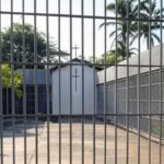 Presídio federal no Brasil com capela e cruz, representando assistência religiosa na prisão.