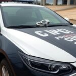 Viatura da Polícia Civil do DF em frente a delegacia, com algemas simbolizando prisão de foragido acusado de estupro.