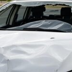 Viatura policial brasileira acidentada em rua de Brasília, representando custos estatais de acidentes.