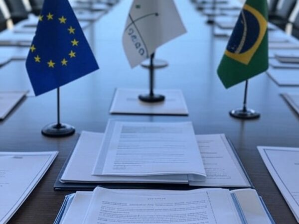 Bandeiras da UE e Mercosul em frente ao Palácio do Itamaraty em Brasília, representando acordo de livre-comércio com PIB de US$ 22 trilhões.