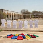 Pátio de escola no Itapoã com uniformes e casacos coloridos, representando punição por vestimenta inadequada em CED 01.