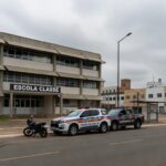 Escola pública em Brasília com viatura da Polícia Militar do DF estacionada na frente, representando afastamento de agentes por abuso.