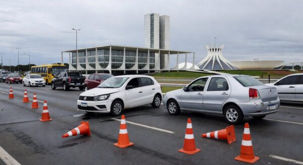 Via urbana em Brasília com veículos acidentados, ilustrando estudo do Detran-DF sobre acidentes fatais e aumento de mortes entre mulheres.