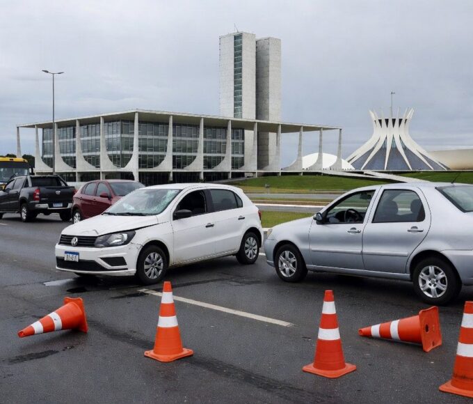 Via urbana em Brasília com veículos acidentados, ilustrando estudo do Detran-DF sobre acidentes fatais e aumento de mortes entre mulheres.