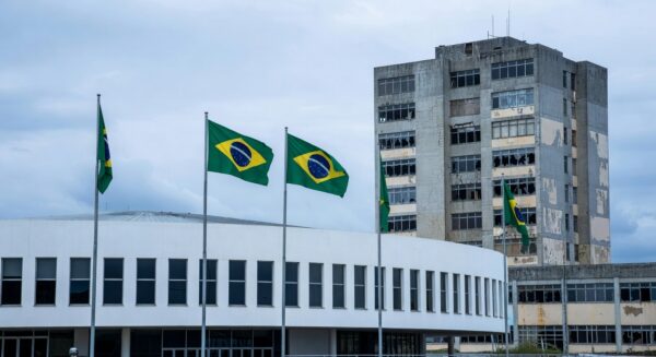 Hospital público em Brasília com fachada deteriorada e faixa de celebração, expondo falhas no sistema de saúde do DF.
