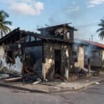 Casa residencial no Brasil danificada por incêndio, com marcas de fogo e fumaça, representando caso de condenação por homicídio.