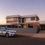 Viatura da polícia em frente a casa no DF, relacionada a prisão por violência doméstica e posse irregular de armas.