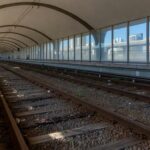 Estação de metrô em Brasília com pilhas de documentos burocráticos, representando atrasos em aquisições no Metrô-DF.
