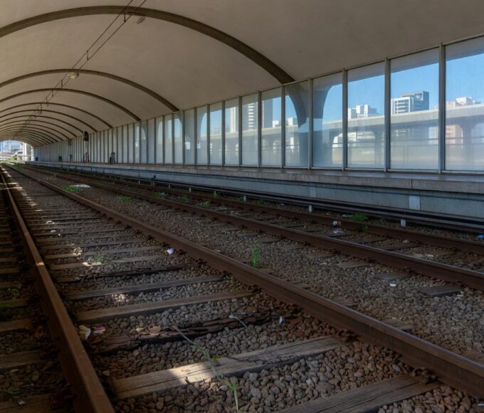 Estação de metrô em Brasília com pilhas de documentos burocráticos, representando atrasos em aquisições no Metrô-DF.