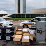 Viaturas da Polícia Civil do DF em Brasília durante Operação Eixo, com símbolos de bloqueio de R$ 1 bilhão contra tráfico.