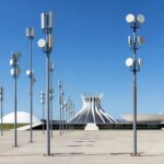 Poste com antena de Wi-Fi público em praça de Brasília, com Congresso Nacional ao fundo, representando expansão do Wi-Fi Social DF.