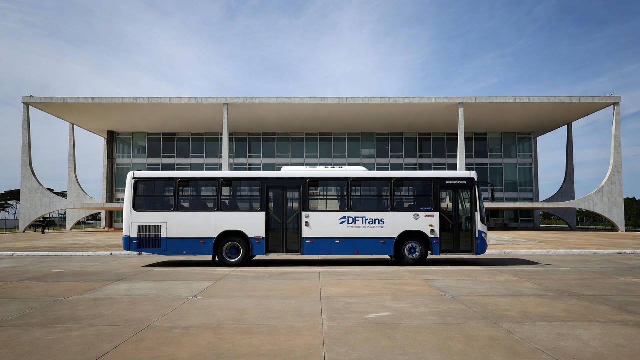 Ônibus de transporte público em Brasília com arquitetura do DF ao fundo sobre tarifa zero