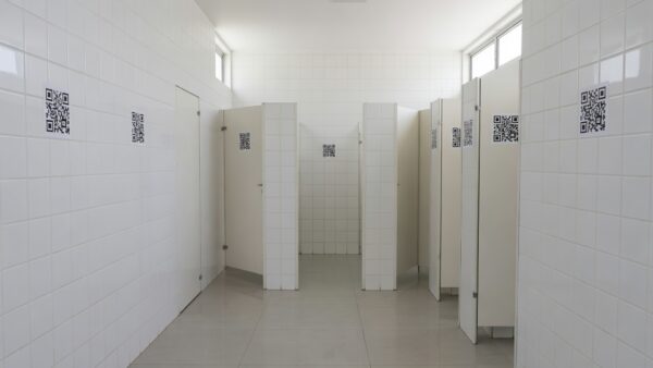 Adesivos com QR Code em banheiro do DF para apoio a vítimas de violência doméstica