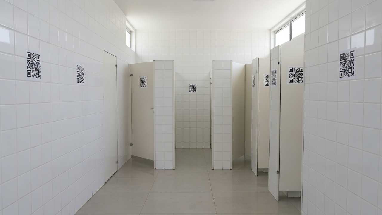 Adesivos com QR Code em banheiro do DF para apoio a vítimas de violência doméstica